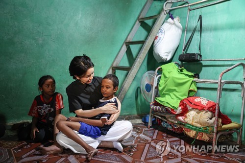 대통령 부인이 11월 12일 캄보디아 프놈펜의 심장병 어린이 집을 방문해 아이를 안고 있다. 아이의 시선은 다른 곳을 보고 있다. 교감이 읽히지 앟는다.  2022.11.22  연합뉴스