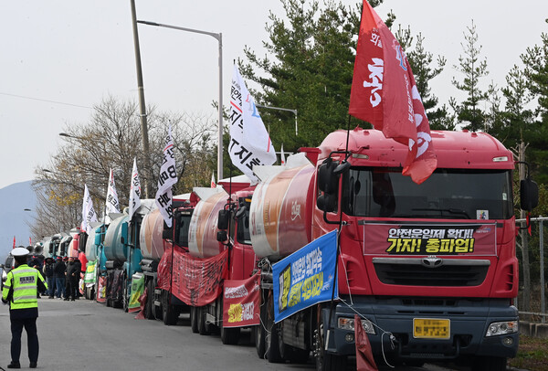 24일 강원 동해시 북평산업단지 내 대한송유관공사 영동지사 앞에서 화물연대 총파업 출정식이 열리고 있다. 출정식에 참가한 조합원들은 차량 30여 대를 도로변에 주차해 놓고 '안전운임 개악저지', '일몰제 폐지', '차종·품목확대'를 요구했다. 2022.11.24 연합뉴스