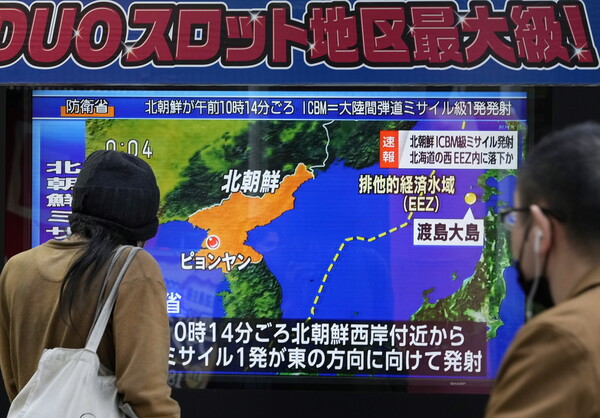 북한이 발사한 '괴물 ICBM'이 일본 홋카이도 서쪽 바다에 떨어진 지난 18일 일본 도쿄의 한 거리에서 주민들이 긴급 속보를 보고 있다. 1만3500명이 근무하는 일본 본섬 최북단의 미 공군 미사와 기지에는 긴급대피령이 내려졌다.  2022.11.18 EPA연합뉴스