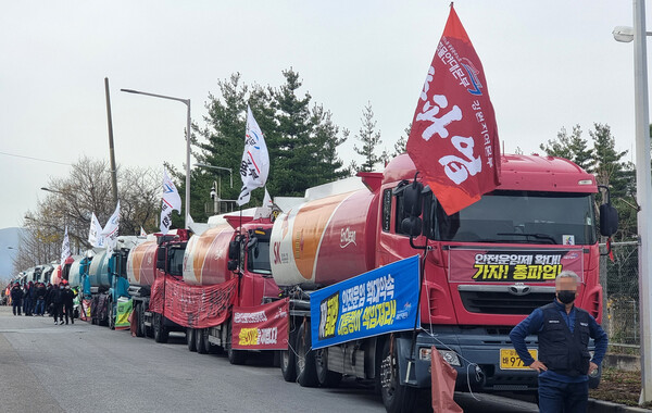 24일 강원 동해시 북평산업단지 내 대한송유관공사 영동지사 앞에서 화물연대 총파업 출정식이 열리고 있다. 출정식에 참가한 조합원들은 차량 30여 대를 도로변에 주차해 놓고 '안전운임 개악저지', '일몰제 폐지', '차종·품목확대'를 요구했다. 2022.11.24. 연합뉴스