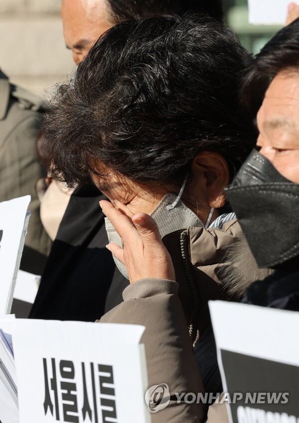 서울시청 본관 앞에서 민변과 참여연대 주최로 열린 ‘10.29 이태원 참사 대비 못한 서울시에 대한 수사 촉구 기자회견’에서 한 유가족이 눈물을 닦고 있다. 2022.12.8. 연합뉴스