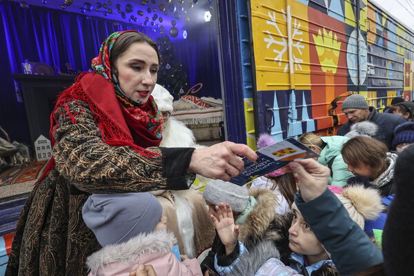 정교회 성니콜라스 축일이었던 지난 22일 우크라이군이 최근 탈환한 하르키우의 기차역에서 한 자원봉사자가 어린이들에게 선물을 나눠주고 있다. 2022.12.22? EPA연합뉴스