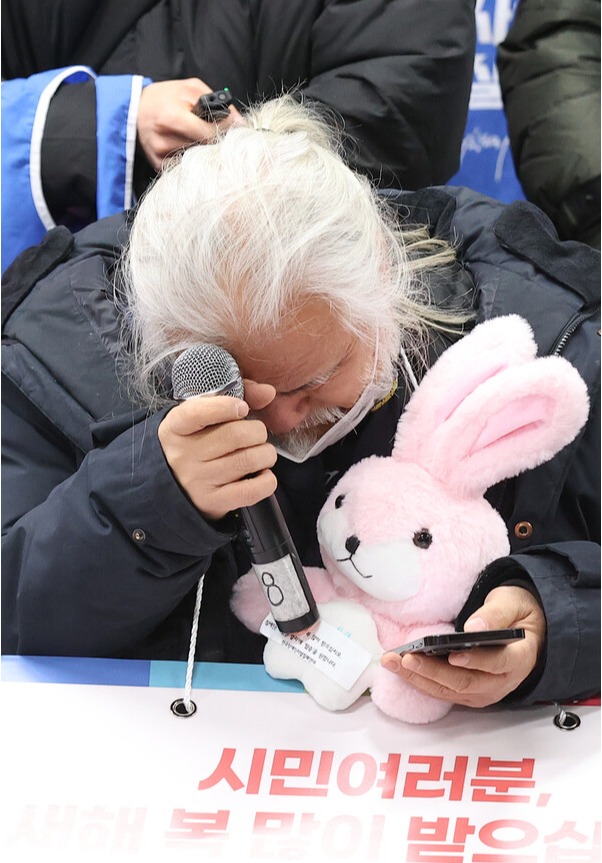 박경석 전국장애인차별철폐연대(전장연) 대표가 2일 오전 서울 지하철 4호선 삼각지역 승강장에서 기자회견을 하는 도중 삼각지역장의 계속되는 경고 방송을 들으며 괴로워하고 있다. 2023.1.2. 연합뉴스