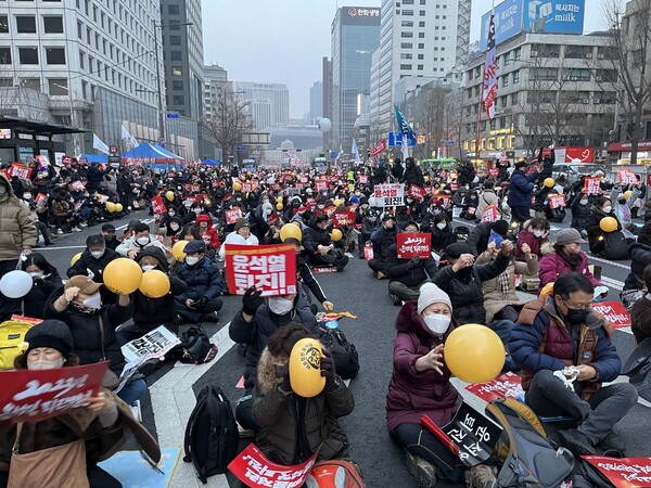 7일 오후 서울 지하철 2호선 시청역~숭례문 앞 대로 구간에서 열린 '22차 촛불대행진'에서 시민들이 윤석열 대통령의 얼굴이 그려진 풍선을 터뜨리고 있다. 2023. 1. 7. 김성진 기자