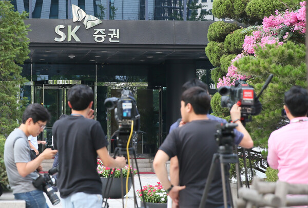 서울남부지검 증권범죄합동수사단이 주가연계증권(ELS) 주가 조작 혐의와 관련해 SK증권 본사를 압수수색한 서울 여의도 SK증권 본사에서 취재진이 대기하고 있다. 2015.7.14. 연합뉴스 자료사진