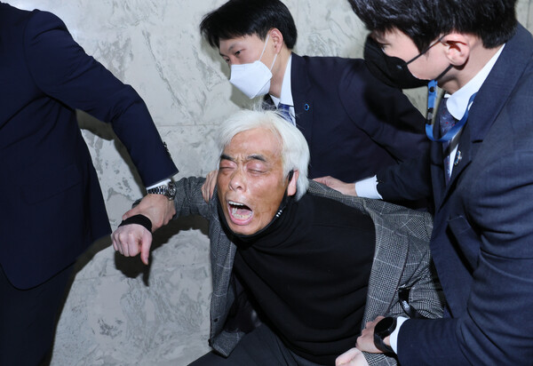 17일 오후 국회에서 열린 '용산 이태원 참사 진상규명과 재발방지를 위한 국정조사특별위원회' 전체회의에서 이종철 10·29 이태원 참사 유가족협의회 대표가 보고서 의결에 앞서 퇴장한 여당 위원들에게 항의하다 제지당하고 있다. 2023.1.17. 연합뉴스