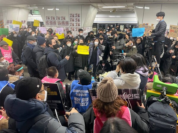 ​20일 전국장애인차별철폐연대 회원들이 지하철 4호선 삼각지역 승강장에서 장애인권리입법·예산 쟁취를 위한 전국집중결의대회를 열고 있다. 사진은 일반 시민들이 햐안 장미와 손팻말을 들고 지지를 보내는 모습. 2023.1.20. 장애인차별철폐연대 제공