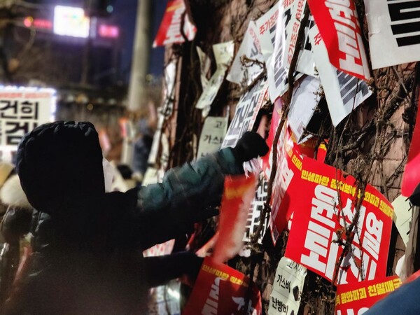28일 오후 서울 도심에서 열린 24차 촛불대행진에 참석한 시민들이 '윤석열 퇴진' '김건희 특검' '가스비·난방비·교통비 고지서' 등이 적힌 팻말을 벽에 붙이고 있다. 2023.1.28. 촛불행동 제공