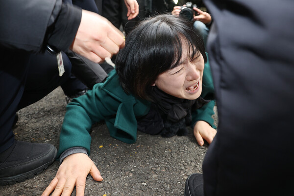 이태원 참사 희생자 이지한 씨 어머니인 조미은 씨가 31일 서울 용산구 대통령실 앞에서 윤석열 대통령과의 면담을 요구하며 출입문에 접근하던 중 경찰에게 저지당하고 있다. 2023.1.31. 연합뉴스