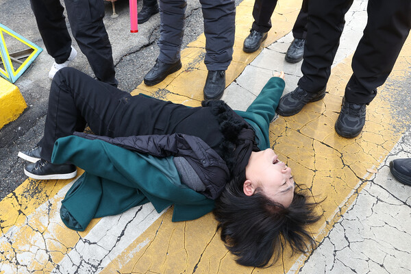 이태원 참사 희생자 이지한 씨 어머니인 조미은 씨가 지난 31일 서울 용산구 대통령실 앞에서 윤석열 대통령과의 면담을 요구하며 출입문에 접근하던 중 경찰에게 저지당하고 있다. 2023.1.31. 연합뉴스
