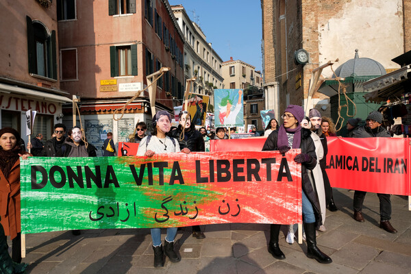 2일 이탈리아 베니스에서 시민들이 이란의 반정부 시위에 연대를 표시하기 위해 이란 시위 구호인 "여성 생명 자유"가 적힌 펼침막을 들고 시위를 벌이고 있다.  2022.2.2. 로이터 연합뉴스