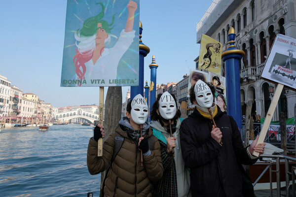 2일 이탈리아 베니스에서 이란의 반정부 시위를 지지하는 시민들이 마스크를 쓰고 "여성 생명 자유"가 적힌 피켓을 들고 연대 시위를 벌이고 있다. 2023.2.2. 로이터 연합뉴스