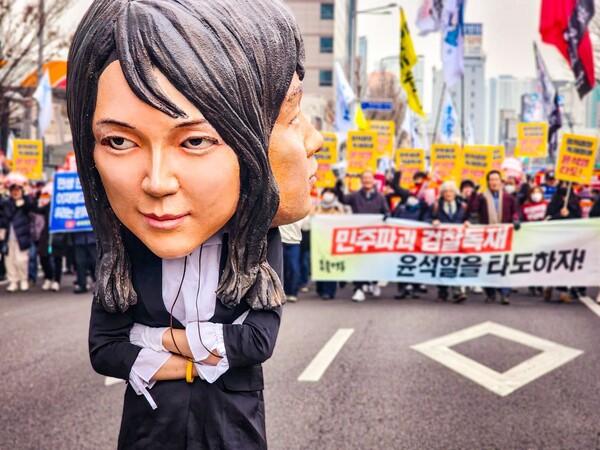 18일 27차 촛불대행진에 참석한 시민들이 서울 도심을 행진하고 있다. 한 시민이 윤석열 대통령 부인 김건희 씨 탈을 쓰고 있는 모습. 2023.2.18. 사진 이호 작가