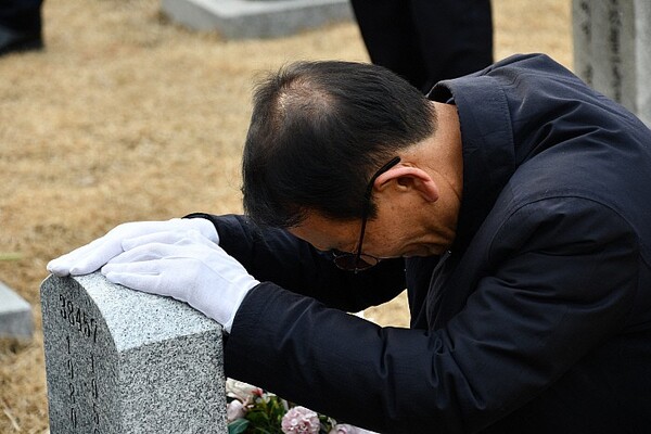 황일봉 5·18부상자회 회장이 지난달 17일 서울 국립서울현충원에서 5·18 당시 사망한 한 특전사 대원의 비석을 어루만지고 있다.  5·18부상자회 제공