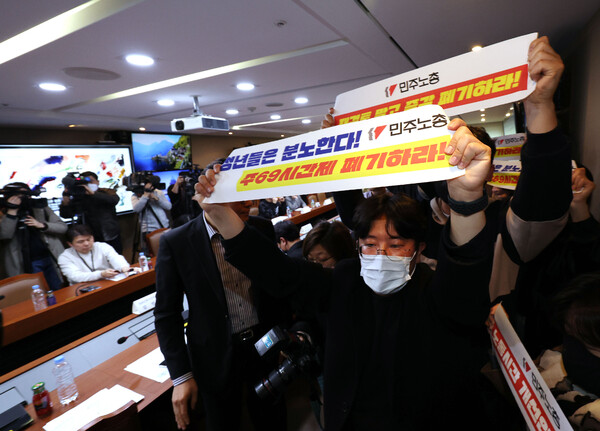 민주노총 청년 활동가들이 15일 오후 서울 중구 서울고용노동청에서 열린 근로시간 기록·관리 우수 사업장 노사 간담회에서 이정식 고용노동부 장관를 향해 주69시간제 폐기를 촉구하며 기습시위를 하고 있다. 2023.3.15 연합뉴스