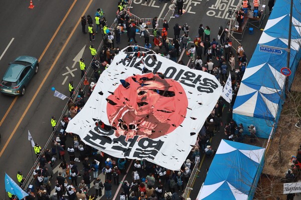 11일 오후 서울 지하철 시청역~숭례문 앞 구간 대로에서 열린 '30차 촛불 대행진'에서 시민들이 '제2의 이완용 윤석열'이라고 적힌 대형 일장기를 찢고 있다. 2023.3.11 사진 이호 작가