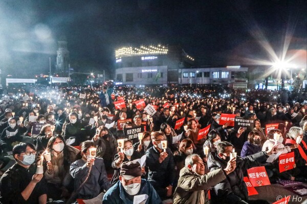 천주교 정의구현전국사제단(정의구현사제단)이 20일 오후 7시 전북 전주시 풍남문 광장에서 연 '검찰독재 타도와 매판매국 독재정권 퇴진 촉구' 시국미사에 참가한 시민들이 촛불을 들며 구호를 외치고 있다. 2023.3.20. 사진 이호 작가