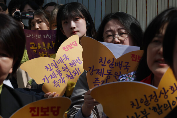 22일 오후 서울 종로구 주한일본대사관 인근에서 열린 제1588차 일본군 성노예제 문제 해결을 위한 수요시위에서 진보당 당원 등 참가자들이 정부의 강제동원 해법에 반대하는 피켓을 들고 있다. 2023.3.22 연합뉴스