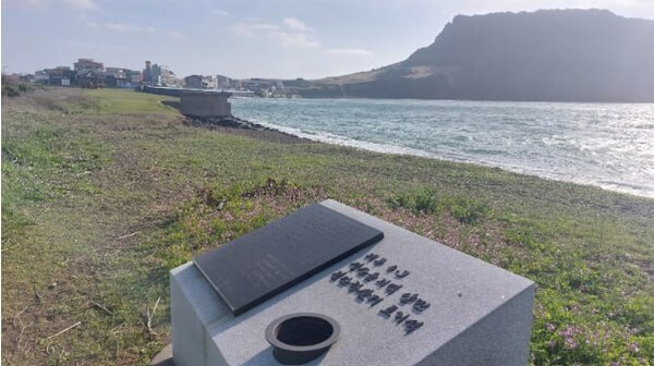 일출봉이 보이는 광치치해변 터진목 학살 현장. 추모석에는 찾는 이가 많지 않은 듯 4월 3일 아침인데도 조화를 꽂는 용기가 비어 있다. © 이봉수  
