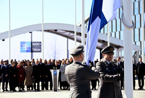 핀란드 군 병사들이 지난 4일 브뤼셀의 나토 본부 앞에서 국기를 게양하고 있다. 2023.4.4. AFP 연합뉴스