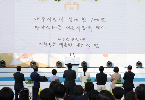 윤석열 대통령 부부가 1일 대구 서문시장 인근에서 열린 '서문시장 100주년 기념식'에서 기념 퍼포먼스를 한 뒤 영상을 보고 있다. 2023.4.1 연합뉴스