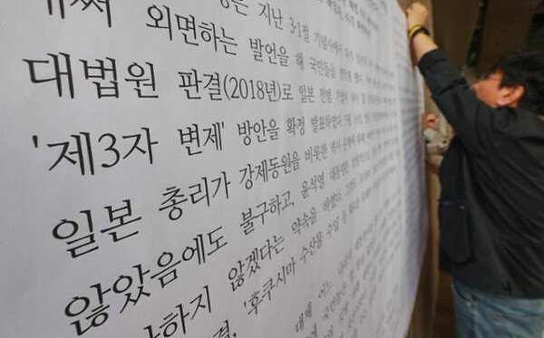 중앙대 교수들이 13일 서울 동작구 중앙대 서울캠퍼스에서 윤석열 정부의 대일 외교를 규탄하는 대자보를 붙이고 있다. 2023.4.13. 연합뉴스