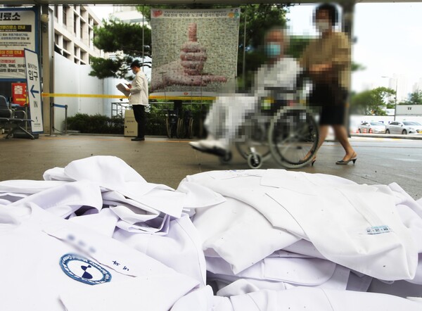 의사들의 파업 당시 경기도의 한 병원에서 환자가 의사들이 벗어놓은 가운 앞을 지나고 있다. 2020. 8.26 연합뉴스