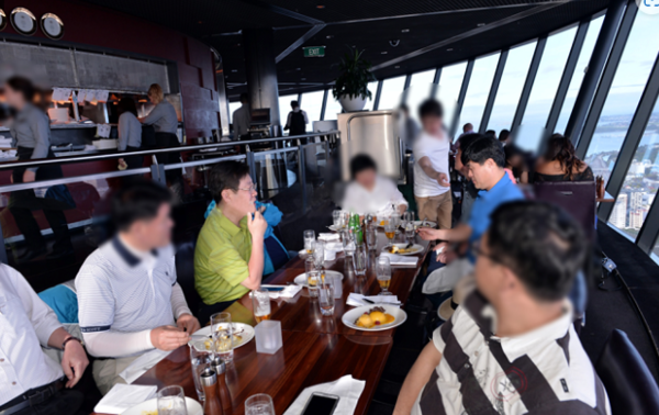 2015년 성남시의 호주·뉴질랜드 출장 당시 첫날 뉴질랜드 오클랜드 스카이타워에서 있었던 저녁 식사 자리. 이재명 당시 시장(올리브 색 상의) 오른쪽에 앉은 사람이 14일 공판에서 증언한 공무원 B씨. 이재명 대표 앞 자리 모자 놓여있는 자리가 유동규 전 본부장, 이 대표 맞은 편 파란색 상의가 고 김문기 씨.