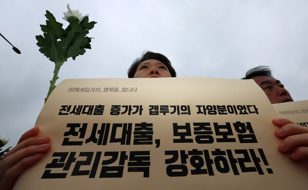 18일 서울 용산구 대통령 집무실 앞에서 열린 전세사기·깡통전세 문제 해결을 위한 시민사회대책위원회 출범 기자회견에서 한 참가자가 피켓을 들고 있다. 2023.4.18. 연합뉴스