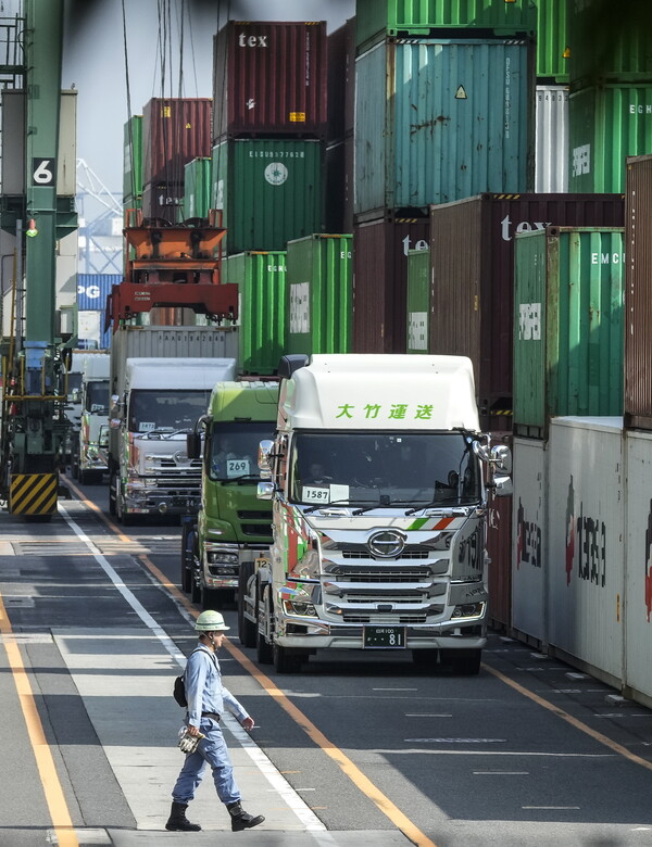  20일 도쿄 아모이 컨테이너 터미널에서 수출 컨테이너들을 선적하고 있는 타워 크레인 아래로 크레인 운전자가 걸어가고 있다. 2023.04.20. EPA 연합뉴스