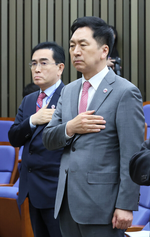 국민의힘 김기현 대표가 27일 오후 국회에서 열린 의원총회에서 국기에 경례하고 있다. 왼쪽은 태영호 최고위원. 2023.4.27. 연합뉴스