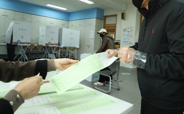 21대 국회의원 선거일인 15일 오전 서울 서초구 방배4동 제6 투표소에서 한 시민이 비례대표 투표용지를 받고 있다. 2020.4.15 연합뉴스