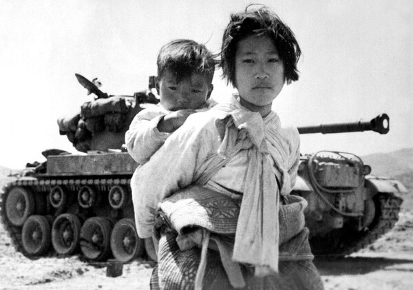 탱크 앞에 서 있는 어린 동생을 업은 소녀. [유엔사령부 홈페이지] 시민언론 민들레