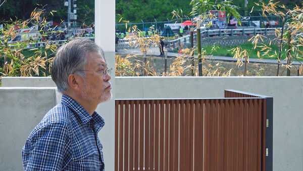 사저 앞 시위대의 모습을 물끄러미 바라보고 있는 문재인 대통령. 사진 엠프로젝트