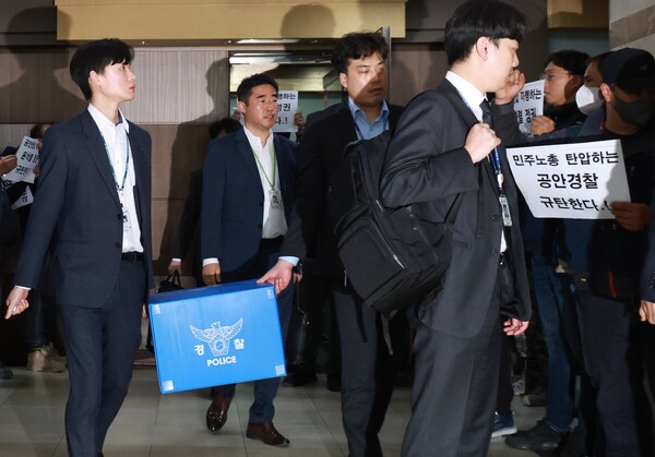 3월 24일 서울 영등포구 민주노총 건설노조 서울경기북부건설지부 사무실에서 압수수색을 마친 경찰들이 압수물을 들고 나서자 노조원들이 항의하고 있다. 2023.3.24. 연합뉴스.