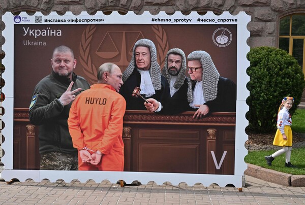 11일(현지시각) 우크라이나 수도 키이우에서 블라디미르 푸틴 러시아 대통령이 수갑을 찬 채 네덜란드 헤이그의 국제형사재판소(ICC)에 선 모습을 묘사한 이미지를 담은 우표 모양의 플래카드가 세워져 있다. ICC는 지난 3월 푸틴 대통령에 대한 체포영장을 발부한 바 있다. 2023.05.12. AFP 연합뉴스