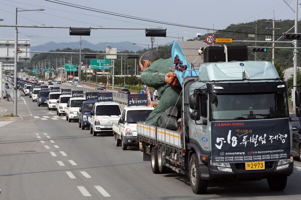 27일 광주 북구 망월묘지공원 인근 도로에서 전두환 전 대통령을 풍자한 작품 518점을 실은 트럭이 줄지어 달리고 있다. 작품은 5·18 40주년 저항의 밤 문화제가 열리는 광주 동구 5·18민주광장으로 집결한다. 2020.6.27. 연합뉴스