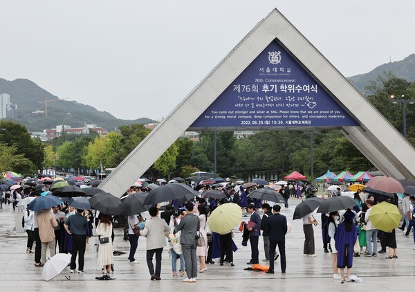 비가 내린 29일 서울 관악구 서울대학교 열린 제76회 후기 학위수여식을 마친 졸업생들이 교문 인근에서 사진을 찍고 있다. 2022.8.29. 연합뉴스 자료사진
