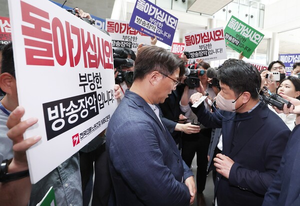 한동훈 법무부 장관 개인 정보 유출 의혹과 관련해 MBC 사옥 수색에 나선 경찰이 이를 막아선 MBC 노조원들에게 신분증을 들어보이고 있다. 2023.5.30. 연합뉴스