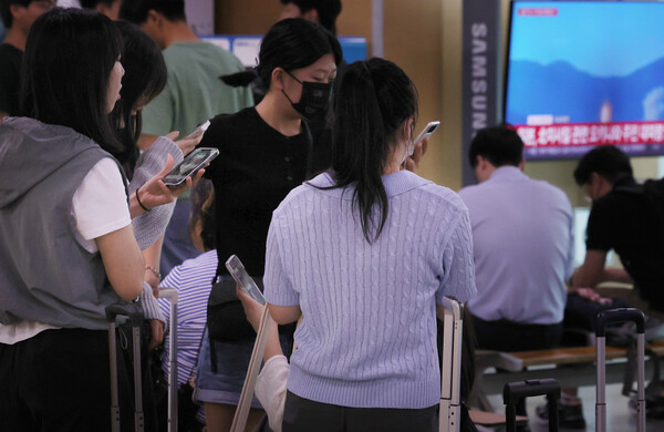 북한이 31일 오전 6시29분께 평안북도 동창리 일대에서 남쪽 방향으로 북한이 주장하는 우주발사체를 발사했다고 합동참모본부가 밝혔다. 이날 오전 서울역 대합실 TV에 관련 뉴스속보가 나오는 가운데 수학여행을 떠나기 위해 모인 학생들이 갑작스럽게 울린 경보음을 듣고 휴대전화 위급재난문자를 확인하고 있다. 행안부는 "서울특별시에서 발령한 경계경보는 오발령"이라고 정정했다. 2023.5.31 연합뉴스