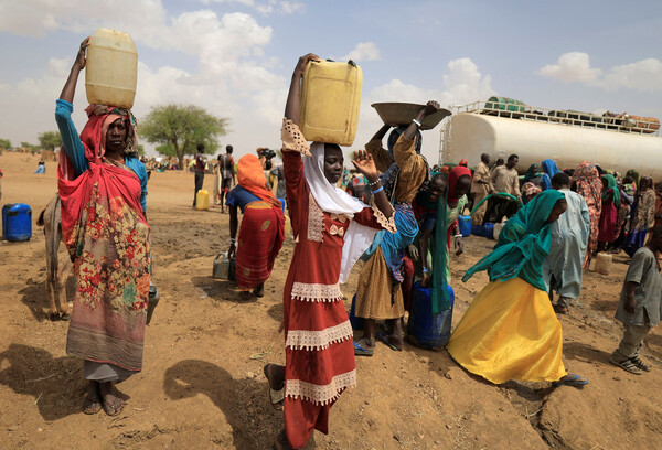 아프리카 수단에서 한 달 가까이 벌어지고 있는 정부군과 준군사조직 신속지원군(RSF)의 유혈 충돌 사태를 피해 이웃 국가 차드로 넘어온 난민들이 10일(현지시각) 물을 길어 임시보호소로 돌아가고 있다. 수단에서는 지난달 15일부터 압델 파타 부르한 장군이 이끄는 정부군과 모하메드 함단 다갈로 사령관이 지휘하는 RSF의 무력 분쟁으로 600명 이상이 숨지고 5천여 명이 다쳤다. 2023.05.12. 로이터 연합뉴스