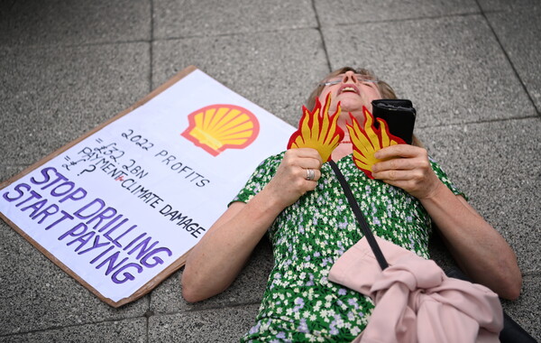 5월 23일(현지시각) 한 여성이 국제적 석유기업 셸의 주주총회가 열리는 영국 런던 엑셀 센터에서 쫓겨난 뒤 바닥에 누워 시위하고 있다. 이날 기후 활동가들은 셸이 환경 오염을 유발한다며 주주총회장에서 기업 폐쇄를 촉구하는 시위를 벌였다. 2023.05.23. EPA 연합뉴스