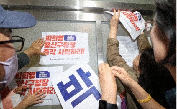 이태원 참사 유가족들이 8일 오전 박희영 용산구청장이 문을 잠그자 사무실 입구에 사퇴 촉구 손팻말을 붙이고 있다. 2023.6.8. 연합뉴스