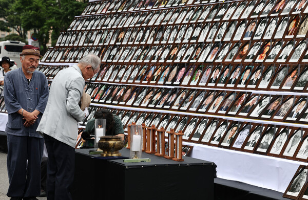 10일 오후 서울시청 앞 도로에서 열린 제32회 민족민주열사·희생자 범국민 추모제에서 한 시민이 헌화 및 묵념을 하고 있다. 2023.6.10. 연합뉴스