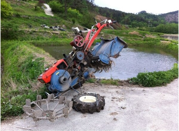 논에 들어가려고 고무바퀴를 쇠바퀴로 갈아 끼우고 있다.