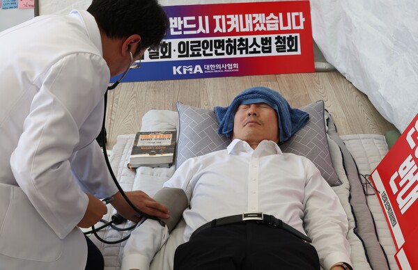 지난달 1일 서울 용산구 의사협회 회관 앞에서 이필수 의협회장이 단식 중 의료진의 건강 상태 체크를 받고 있다. 의협회장은 간호법에 반대해 단식을 벌였다. 2023. 5.1. 연합뉴스