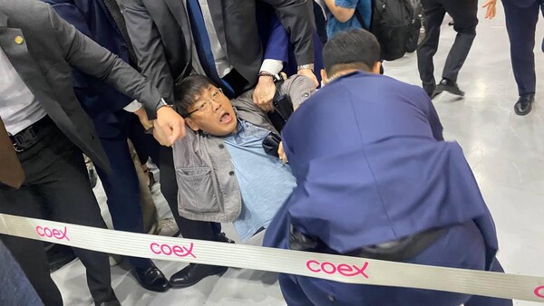 14일 서울 강남구 코엑스에서 개막한 서울국제도서전에서 송경동 시인이 문화계 블랙리스트 사건에 연루된 오정희 작가의 홍보대사 철회를 요구하자 대통령실 경호원들이 송 시인을 끌어내고 있다. 한국작가회의 제공.