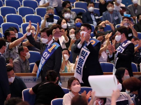더불어민주당이 새 지도부를 선출하는 8·28 전당대회 지역 순회 경선을 시작한 6일 강원 원주시 한라대학교 대강당에서 열린 합동연설회에서 이재명, 박용진, 강훈식 당 대표 후보가 당원들에게 인사하며 입장하고 있다. 2022.8.6. 연합뉴스