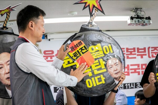 양경수 민주노총 위원장이 27일 오전 열린 '윤석열퇴진운동본부 준비위원회' 발족 기자회견에 참석해 폭탄을 소화기로 끄는 퍼포먼스를 하고 있다. 2023.6.27. 노동과세계 제공