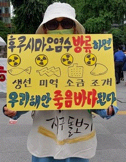 지난달 23일 카톨릭기후행동 금요기후행동 회원이 오염수 방류 반대 손팻말을 들고 1인 시위를 벌이고 있다. 카톨릭기후행동
